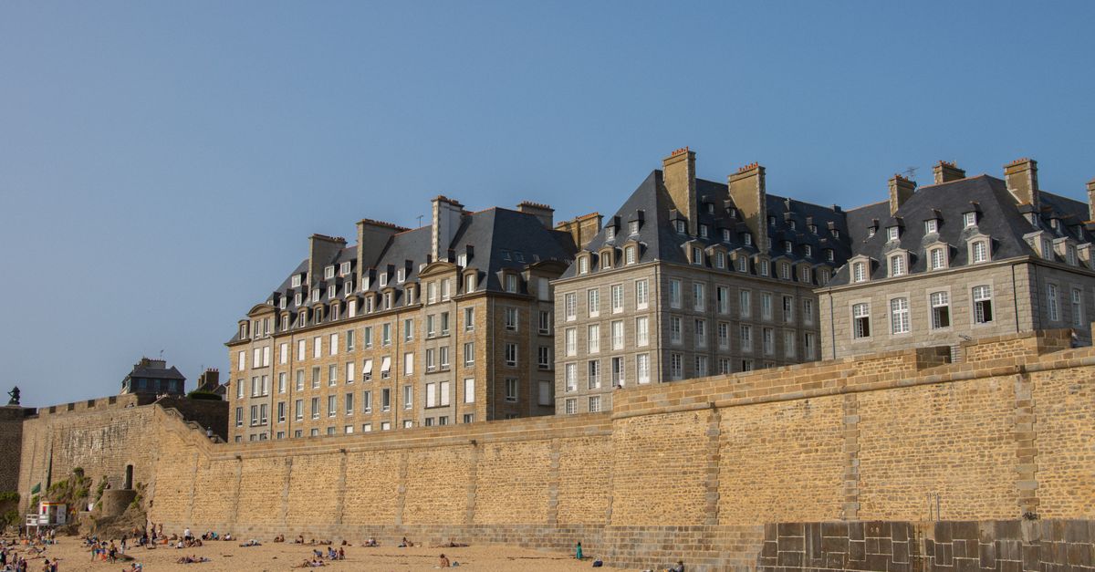 View of historical buildings and stone walls at Saint-Malo beach, Brittany, France.